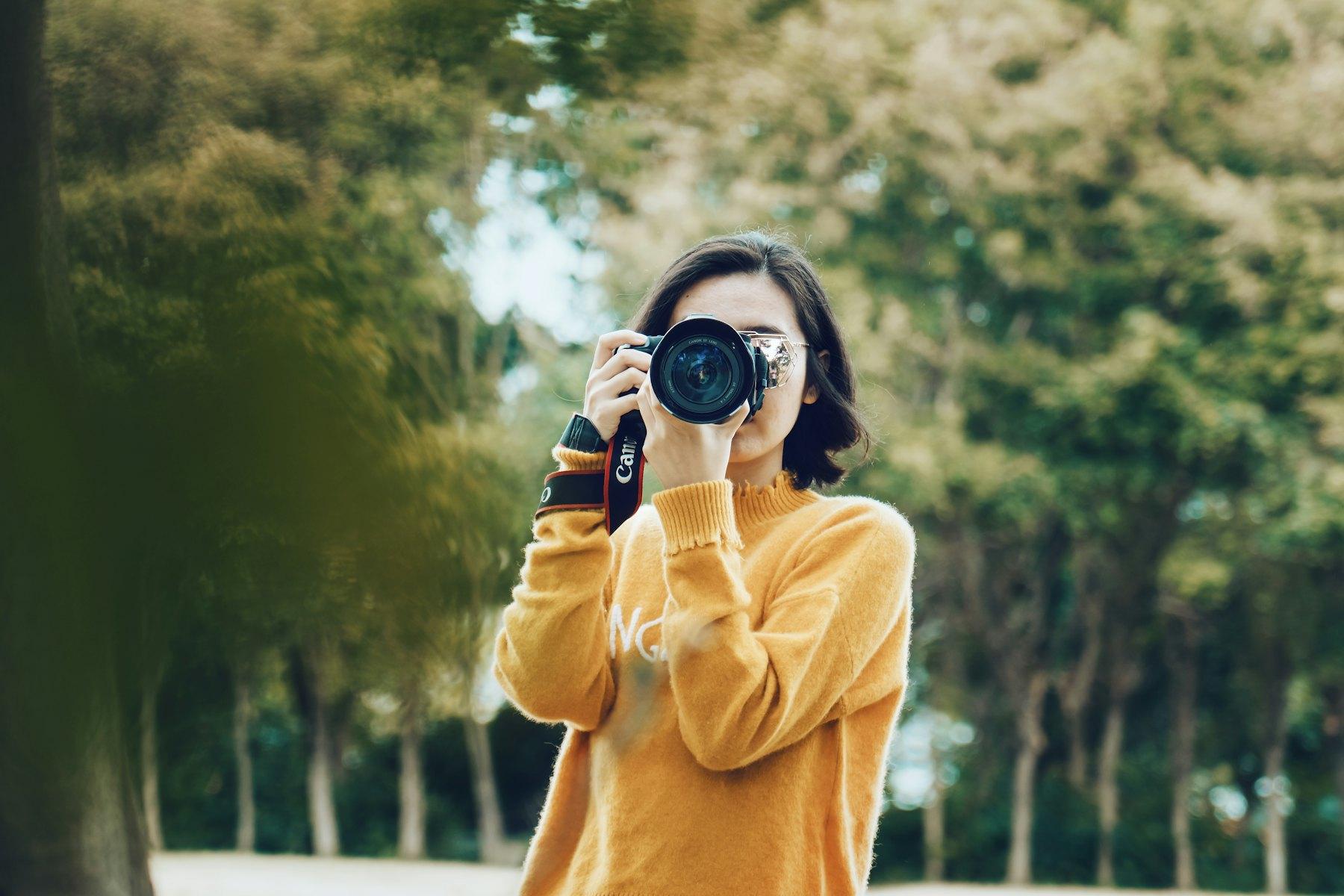 Photographer holding a camera outdoors (placeholder photo)
