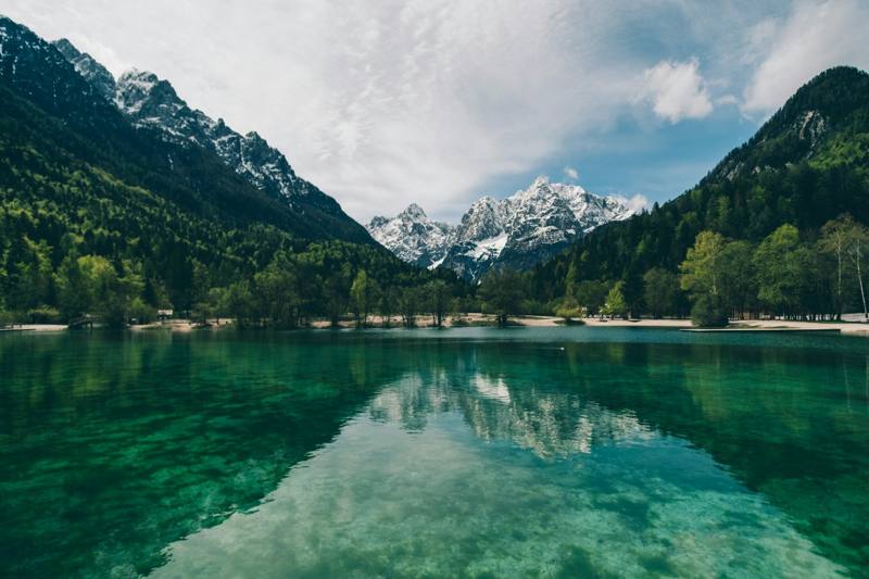 Turquoise mountain lake reflecting snow-capped peaks