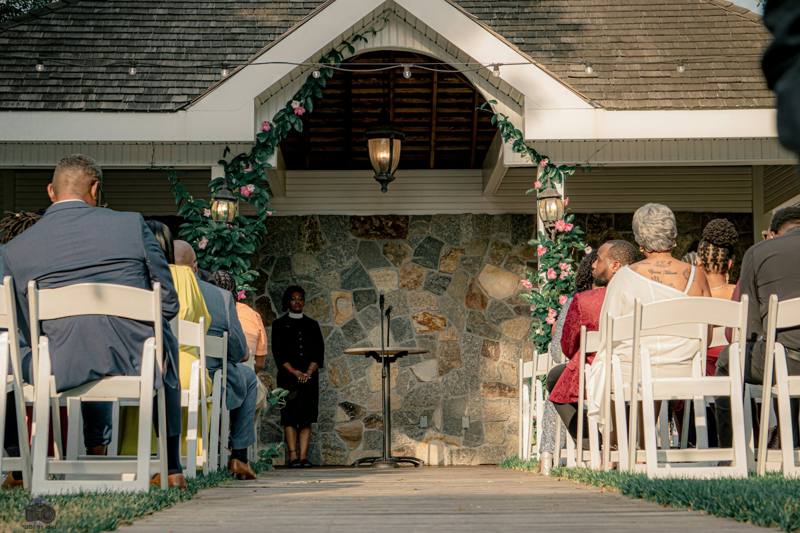 Wedding guests await ceremony under a beautiful floral archway